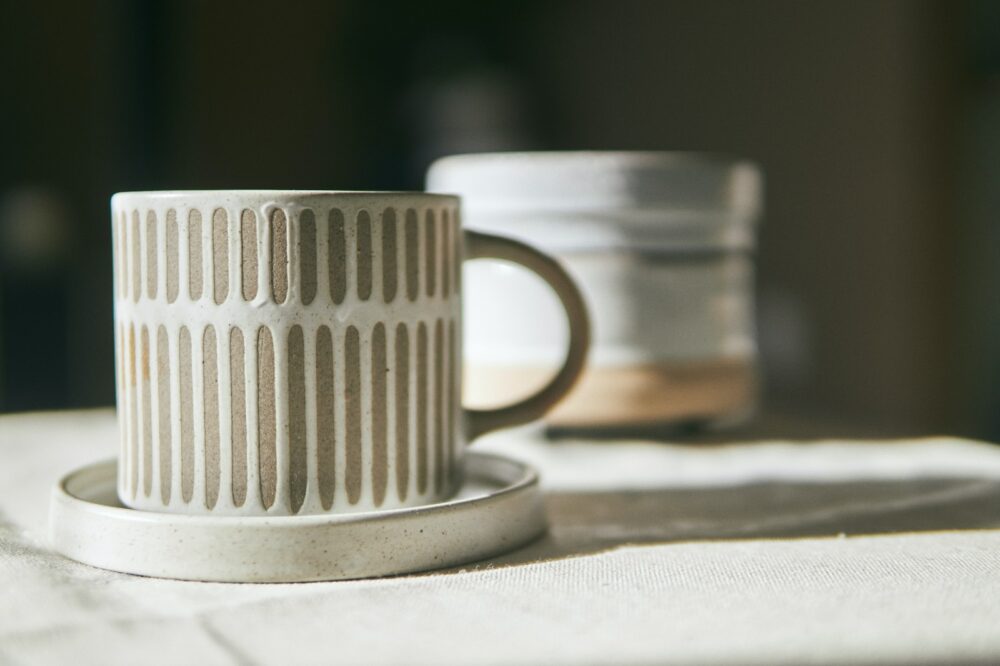 white ceramic mug on white textile
