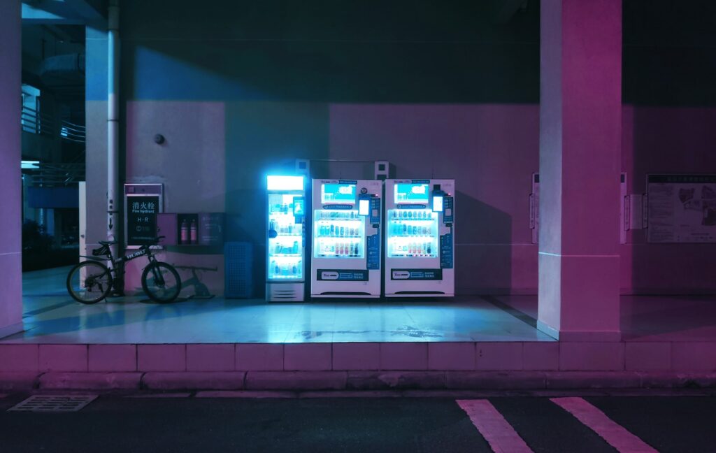 a couple of vending machines sitting on the side of a road