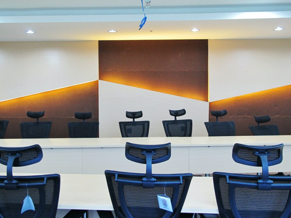 a conference room with chairs and a large painting on the wall